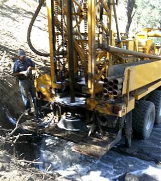 Water well drilling equipment in Northern California actively drilling a borehole
